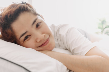 Close up of happy Asian woman just wake up in warm morning of summer.