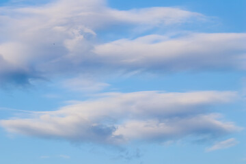 Background of blue sky with white and pink clouds in sunset