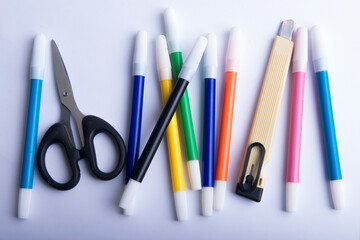 Colorful markers, cutter, and scissors