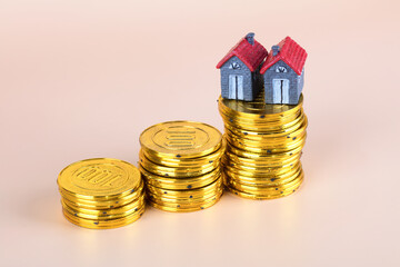A row of increasing gold coins and house models