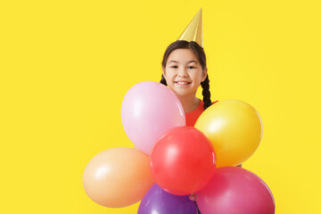 Fototapeta na wymiar Cute little girl with balloons celebrating Birthday on color background