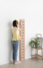 Little girl measuring height at home