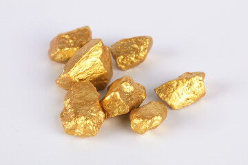 Broken gold nuggets scattered on white background
