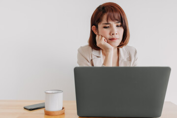 Asian working woman is using laptop on the office desk with white background.