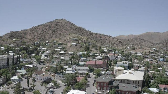 Aerial view of the town of Bisbee in Arizona. This small town is surrounded by mountains and has many building, homes, and trees. 