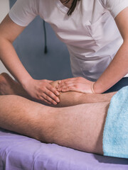 Fototapeta na wymiar two people, physiotherapist massaging man's leg muscles - calves.