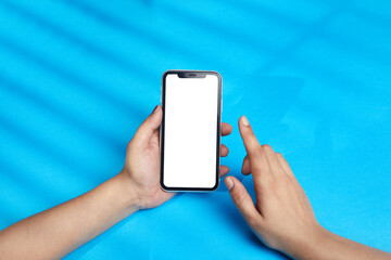 person holding mobile phone, lady using smart phone over blue background with white display for usage