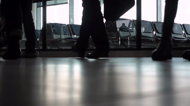 4K ground level video clip of anonymous people walking through an airport terminal with suitcases, bags and baggage