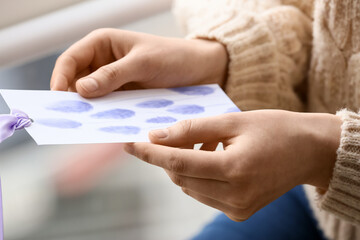 Woman with bookmark in room, closeup