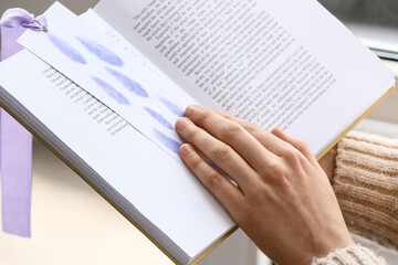Fototapeta premium Woman reading book in room, closeup