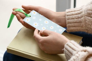 Woman with bookmark in room, closeup