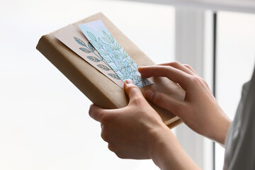 Woman with bookmarks and book at home, closeup