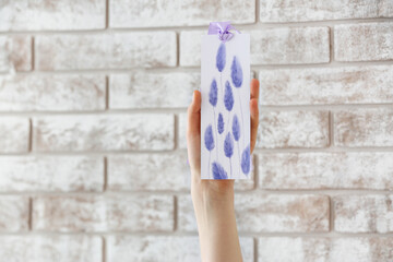 Woman with bookmark on brick background