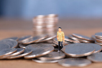 Fototapeta premium Doll model standing in coin pile