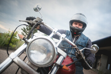 Fototapeta na wymiar Biker in the helmet is sitting on the motorbike.