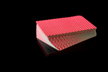 Full deck of playing cards on dark reflective background