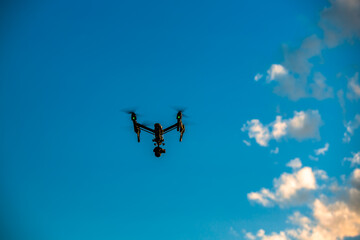 Fototapeta na wymiar Flying drone quadcopter and blue sky clouds