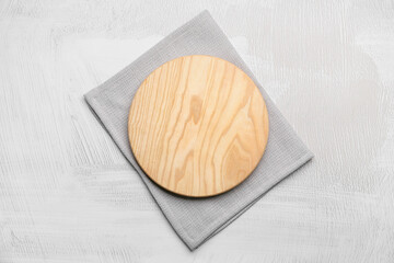 Fabric napkin and wooden board on light background