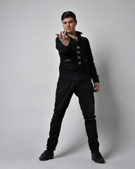 Full length portrait of a brunette man wearing black shirt and gothic waistcoat.  Standing pose...