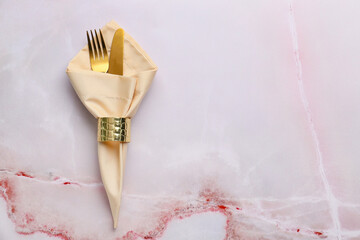 Cutlery and fabric napkin on color background