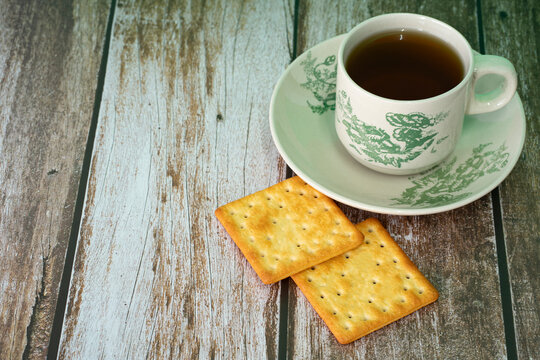 Breakfast serving of cream crackers and a cup of tea. Selective focus points. Blurred background