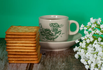 Breakfast serving of cream crackers and a cup of tea. Selective focus points. Blurred background