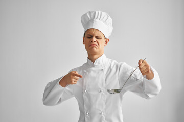 a man in a chef's uniform points a finger at a ladle