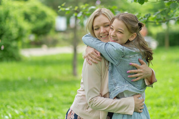 happy mother with her daughter hugging a teenager in the summer. Caring happy mother enjoy day with...