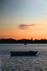 Naklejka premium Small boat and beautiful sunset over Stobrec, Croatia.