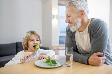 Mature man and his son having breakfast together