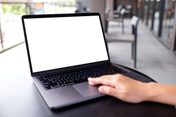 Mockup image of a woman using and typing on laptop computer with blank white desktop screen in cafe