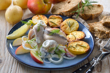 Marinierte Matjesfilets mit Äpfeln, dazu heiße Ofenkartoffeln mit Rosmarin  - Salty herring fillets with apple slices, served with crispy baked rosemary potatoes