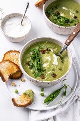 Cream of green peas soup with toasts and sour cream.