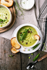 Cream of green peas soup with toasts and sour cream.