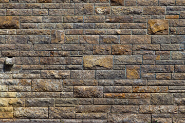 Natural brown and beige stone brick wall background texture