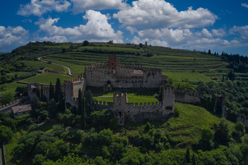 Soave castle aerial view, province of Verona, Italy. Aerial panorama of Italy castles. The famous medieval castle on the hill. Italian historic castles.