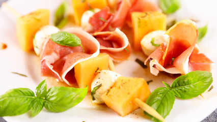 melon salad on stick with mozzarella and prosciutto ham