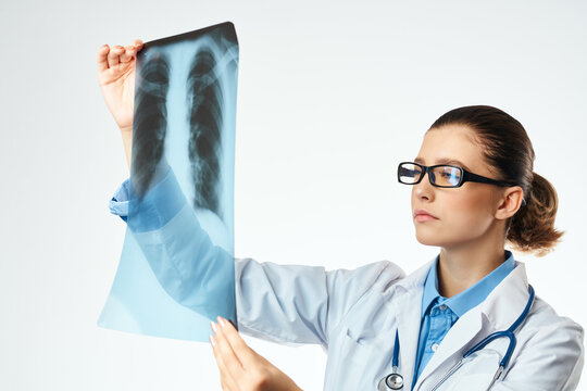 a nurse in a white coat looking at an x-ray Professional examination