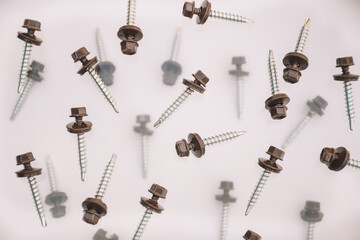 Collection of screw heads. Background of screws and dowels. Levitation of objects on a white...