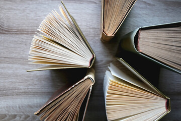 Vintage hardcover books on a wooden table. Top view.