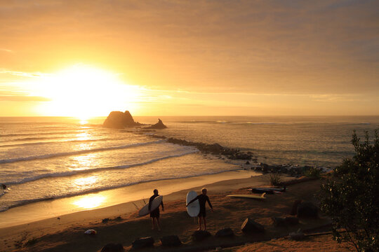 Surfers at sunrise in Mangawhai New Zealand