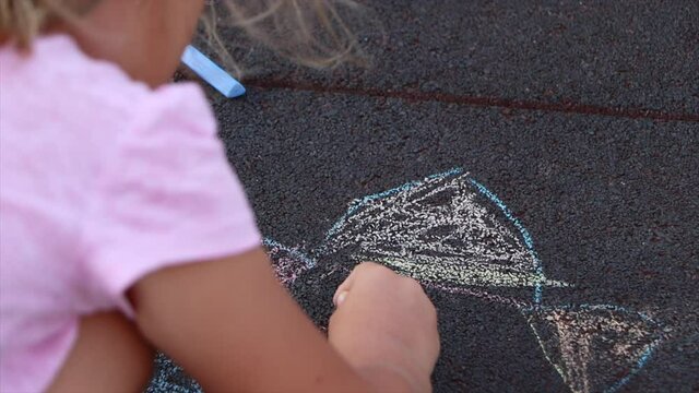 Little girl drawing pics by crayon outdoor