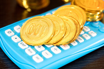 Golden gold coin on calculator