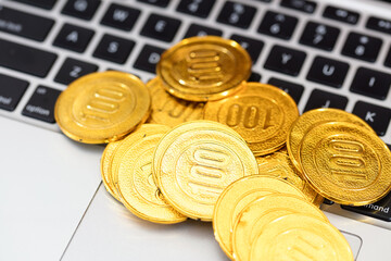 Gold coins on laptop keyboard