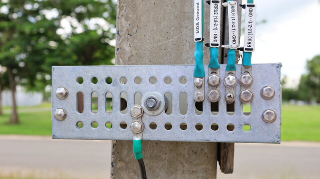 Ground bar with cable on pole. The lightning protection grounding system of the mobile telecommunication substation transmits Wi-Fi signals. Close focus and select the subject