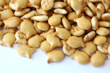 Heap of fish shaped cookies, salted crackers on a white  background.