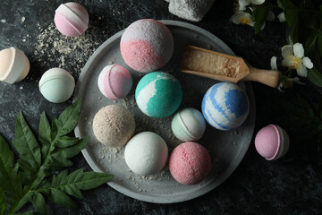 Body care concept with bath balls on black smokey table