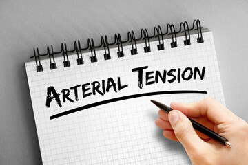 Arterial tension text on notepad, medical concept background