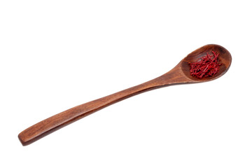Saffron background. Close-up of red safran spice threads or strands in a rustic wooden spoon isolated on a white background. Clipping path.Macro.
