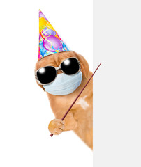 Puppy wearing sunglasses, party cap and medical protective face mask  points on empty white banner. Isolated on white background